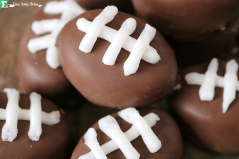 Easy game day snack idea. Take the traditional chocolate covered peanut butter balls to the next level with these Peanut Butter Footballs.