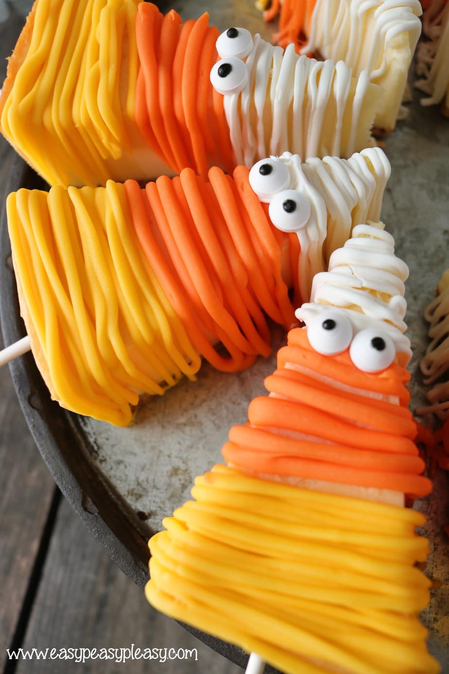 Mummified Candy Corn Cheesecake on a Stick at easypeasypleasy.com